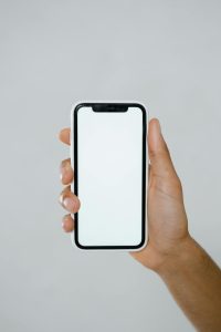A minimalist mockup of a hand holding a smartphone with a blank screen.